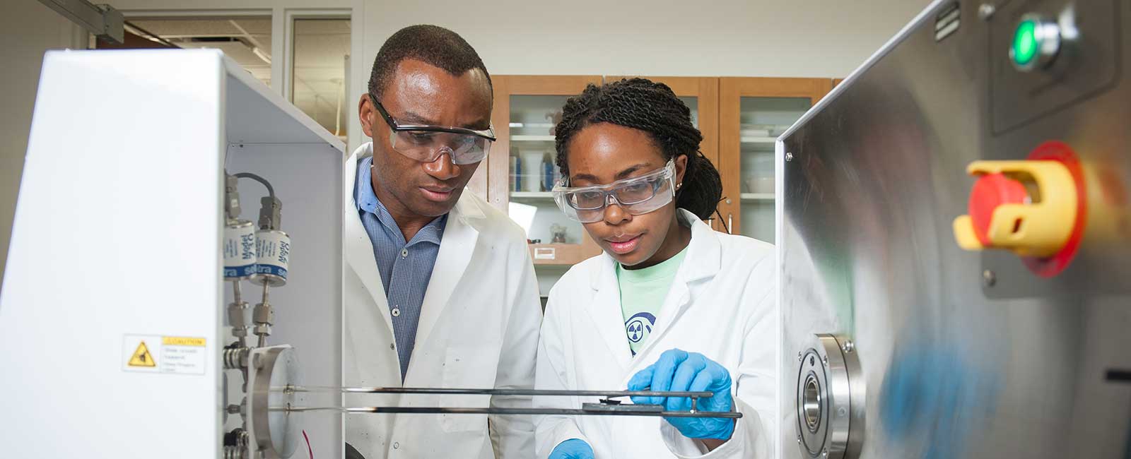 Faculty member observing a student working in a lab