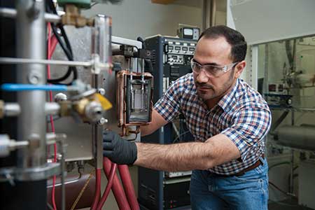Researcher adjusts equipment in a lab.
